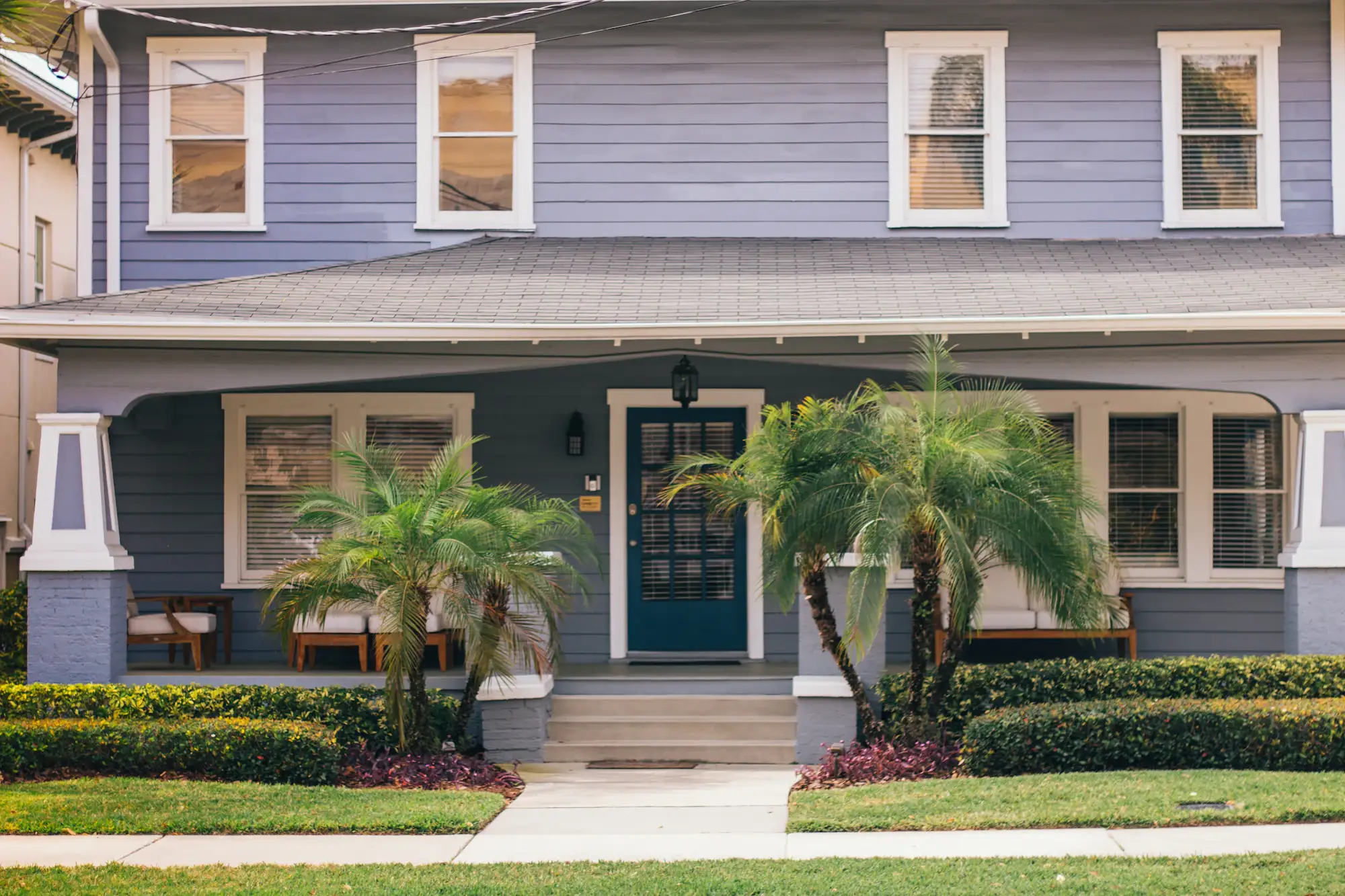 A Florida house with a front porch and palm trees