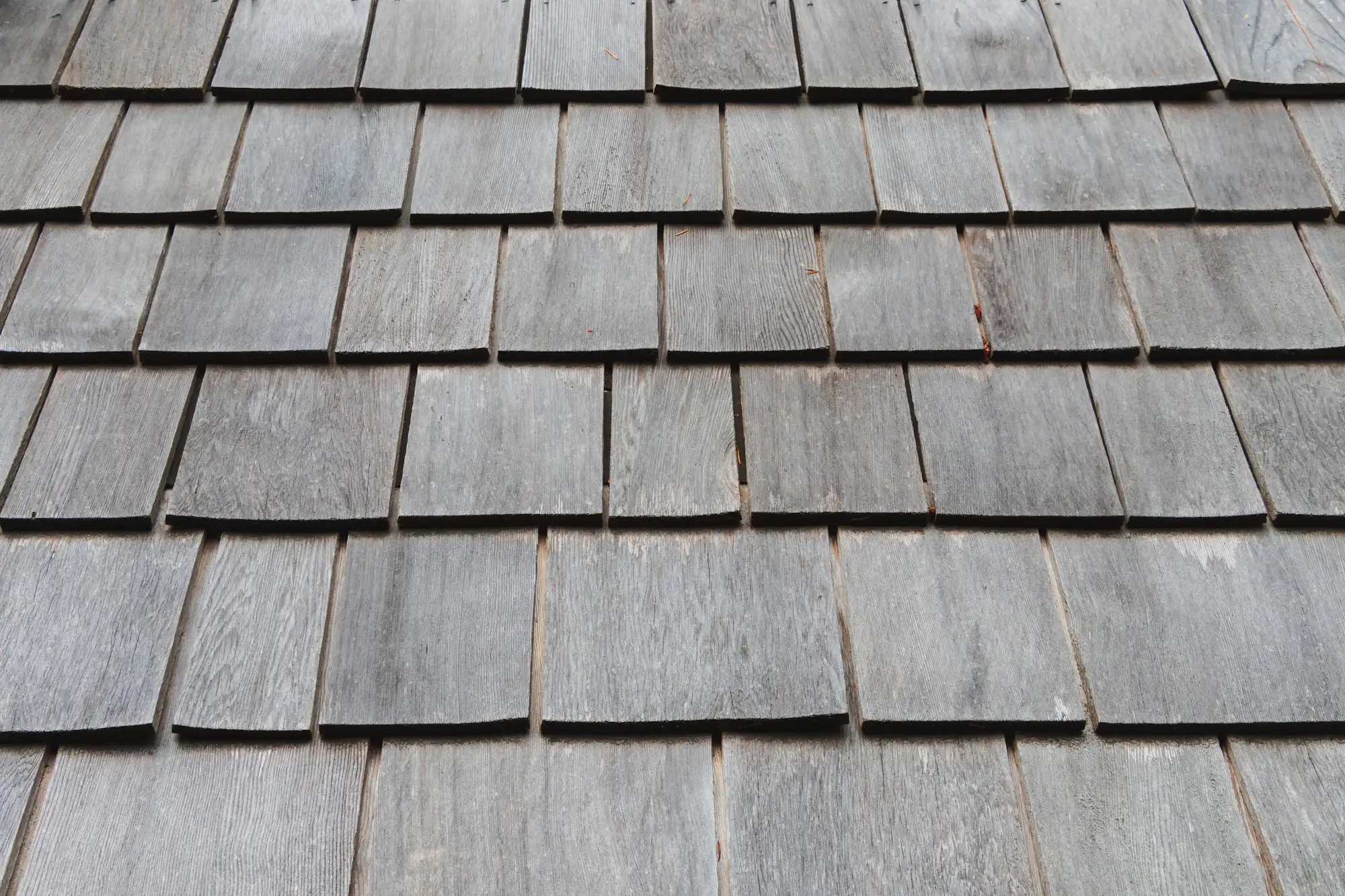 Weathered, faded asphalt shingles on an aging roof
